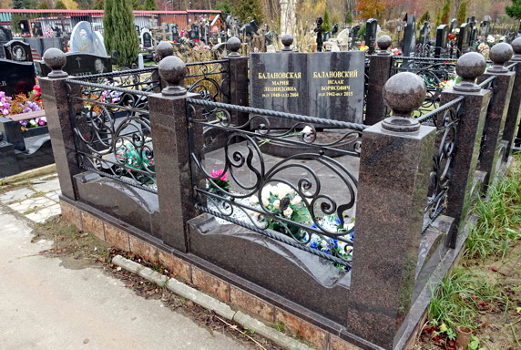 Памятник в виде раскрытой книги за комбинированной оградкой